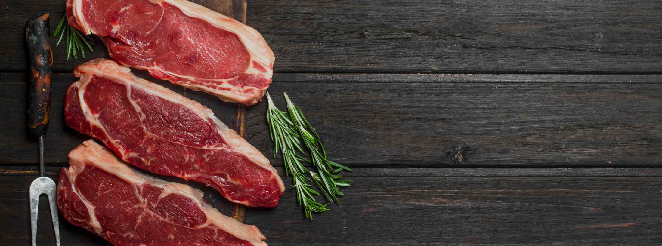 steaks-laid-out-on-wooden-table steaks laid out on wooden table