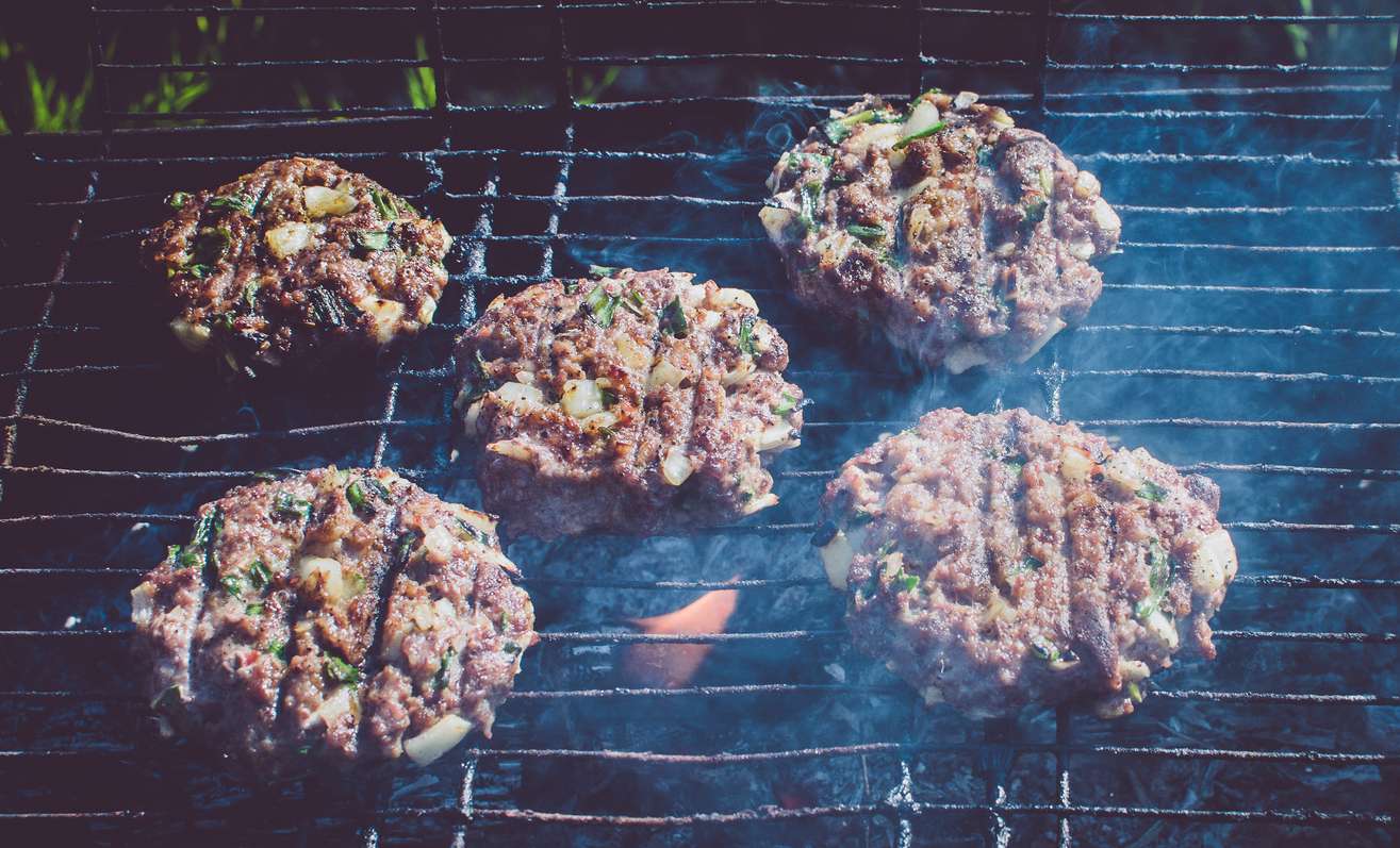 Lamb, zucchini and halloumi burger patties on grill